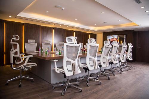 a conference room with white chairs and a table at Sulaf Luxury Hotel in Amman