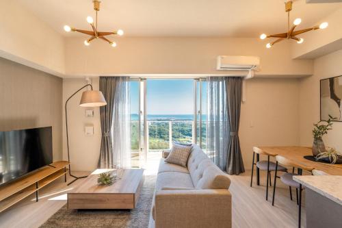 a living room with a couch and a table at モンドミオ沖縄リゾート ライカムヒルズ1403号室 in Okinawa City