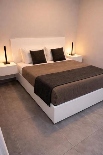 a bedroom with a large bed with two side tables at Villa O Pomar with optional heated pool in Paul do Mar