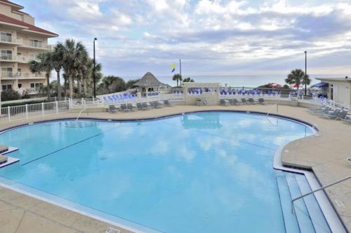 a large blue pool with chairs and a hotel at TOPS'L Tides 704 in Destin