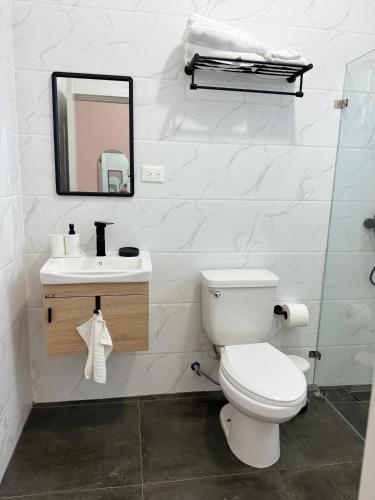 a white bathroom with a toilet and a sink at Hotel Rincón Samaná in Las Galeras