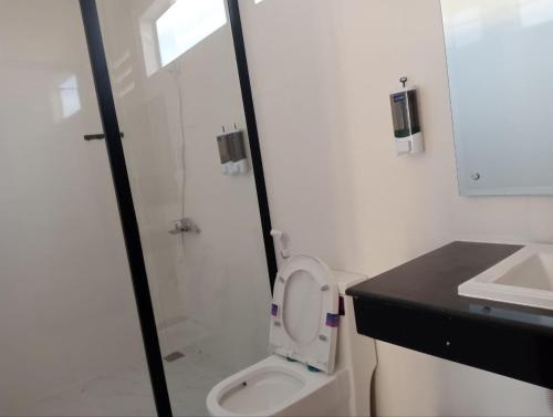 a white bathroom with a toilet and a sink at Good Dream Guest Home in Phumĭ Toch