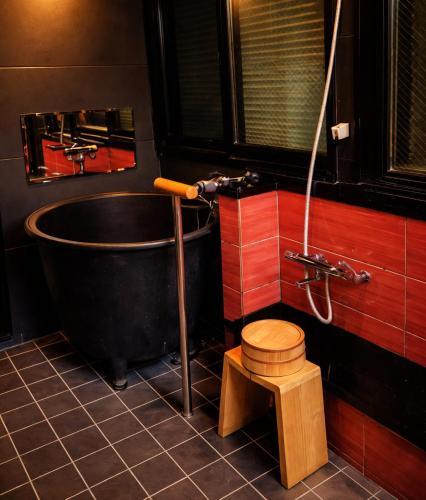 a bathroom with a black tub and a toilet at TSUDOYA Sanno 集家山王 in Osaka