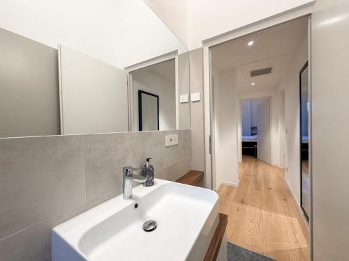 a bathroom with a white sink and a mirror at Design Apartment Archea Terrazza sul Lago Maggiore in Laveno-Mombello