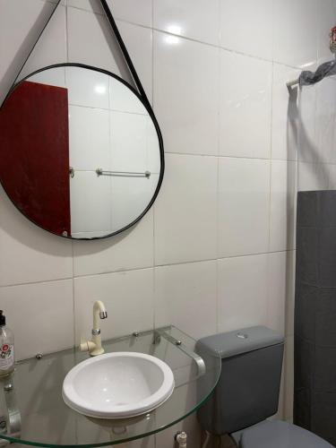 a bathroom with a sink and a mirror and a toilet at Doce Lar Alto Caparaó in Caparaó Velho