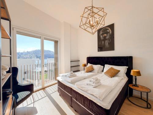 a bedroom with a bed and a large window at Design Apartment Archea Terrazza sul Lago Maggiore in Laveno-Mombello