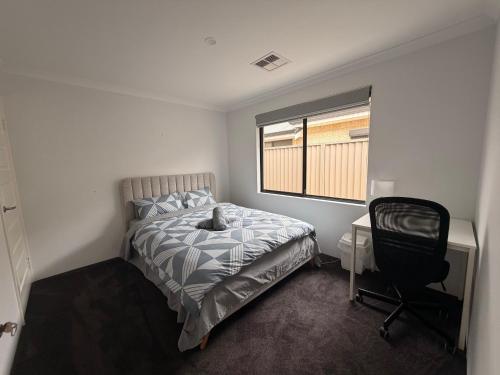 a bedroom with a bed and a desk and a chair at Sweet Home Property Forrestfield in Perth