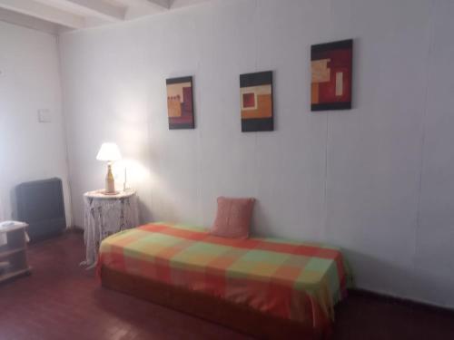 a bedroom with a bed and some pictures on the wall at El Jacaranda in Carmen de Patagones