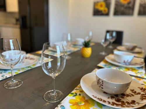 a wooden table with wine glasses and a bowl on it at Sunny Delight Home Near Airport in Hollywood