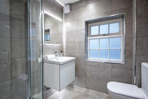 a bathroom with a sink and a toilet and a window at Fifty Two Old Elvet in Durham