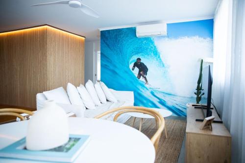 a room with a painting of a surfer riding a wave at El Parche Bilinga Beachside in Gold Coast