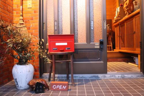 a red box on a stand in front of a door at 上海洋行 Shanghai Yoko in Nagawa