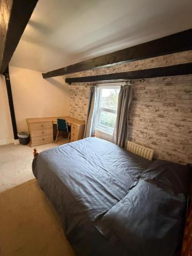 a bedroom with a large bed and a brick wall at Spectacular Period Property Located In Leicester in Leicester