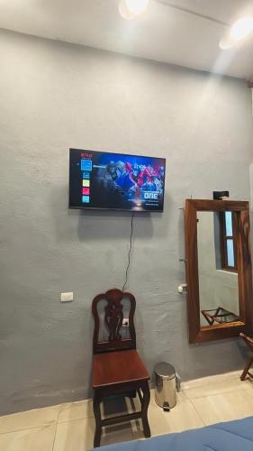 a flat screen tv on a wall with a chair at Casa Mesones in San Miguel de Allende
