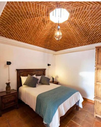 a bedroom with a bed with a wooden ceiling at Casa Mesones in San Miguel de Allende