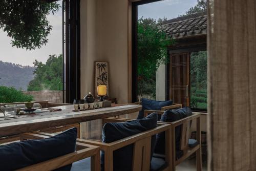 a dining room with chairs and a large window at 杭州喜在山舍 in Qingshandian