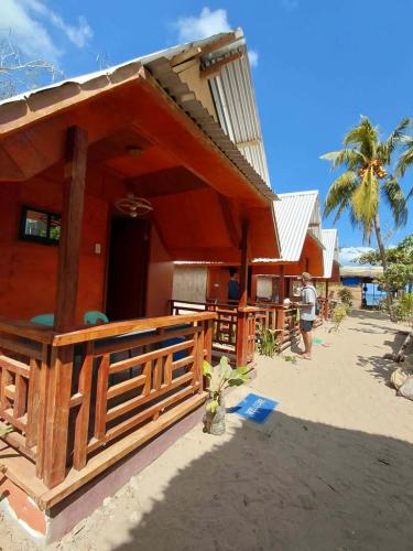 a man standing outside of a house on the beach at Emil's Beach Cottage in El Nido