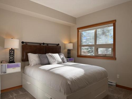a bedroom with a large bed and a window at One Bedroom Mountain View Condo - Lodges at Canmore in Canmore