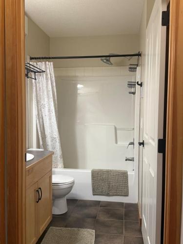 a bathroom with a white tub and a toilet at One Bedroom Mountain View Condo - Lodges at Canmore in Canmore