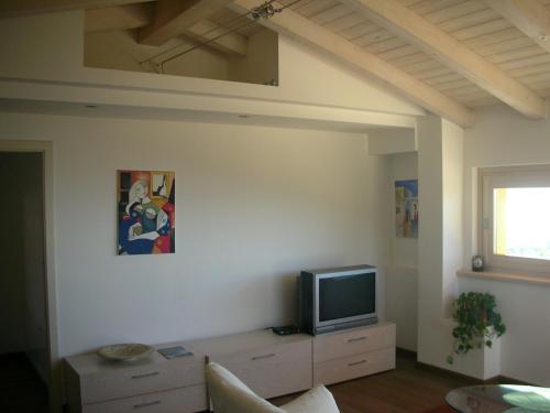 a living room with a tv on a white wall at Villa Susina Casa Vacanze in Toscolano Maderno