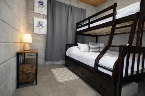 a bedroom with a wooden bunk bed and a night stand at Private Mountain Cabin with Garden Views in Zarcero