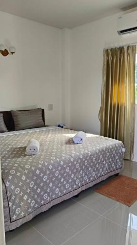 a bedroom with a bed with two towels on it at Ban Pai Khlung Resort in Chanthaburi
