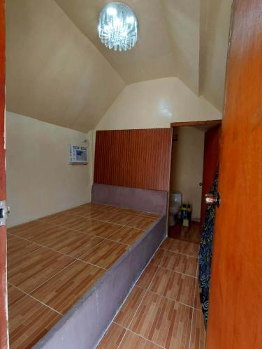 a room with a bed and a chandelier at Emil's Beach Cottage in El Nido