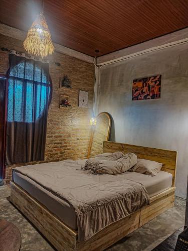a bedroom with a large bed with a chandelier at Loti Guest House in Kupang