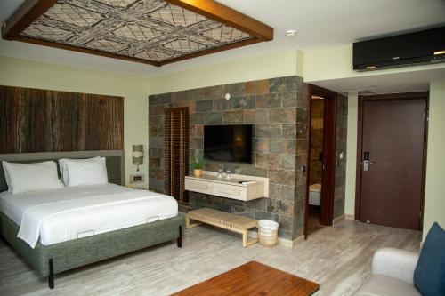 a bedroom with a bed and a sink and a tv at Gelibolu Taş Konak Hotel in Gelibolu