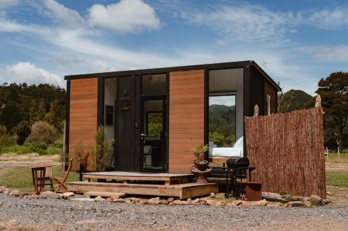 a tiny house sitting on a pile of rocks at Omoho Stream X by Tiny Away in Kennedys Bay