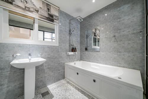 a bathroom with a sink and a bath tub and a sink at Hotel Avenue in Tansa-gol