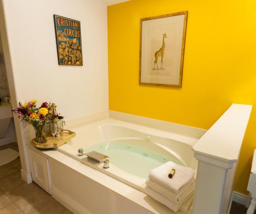 a bath tub in a bathroom with yellow walls at Inn at Occidental in Occidental