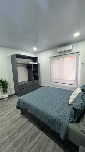 a bedroom with a large bed and a window at Riverside Apartments in Jacó