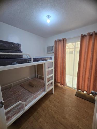 a bedroom with a bunk bed with orange curtains at Sanremo Oasis Staycation in Cebu City