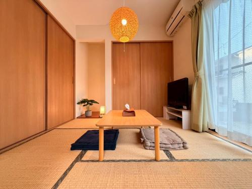 a living room with a table and a tv at tomari in Okayama