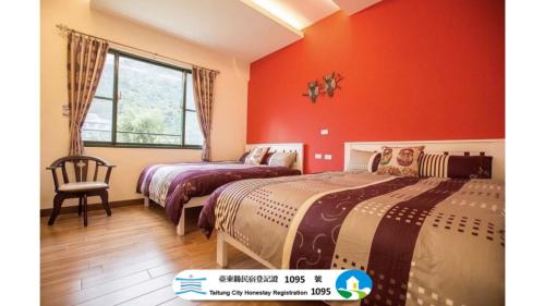 two beds in a room with red walls at 春夏秋冬民宿 - 臺東縣民宿1095號 in Guanshan