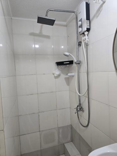 a bathroom with a shower with a sink and a toilet at Sanremo Oasis Staycation in Cebu City