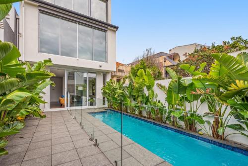 a swimming pool in front of a house with plants at Complete Host Middle Park House in Melbourne