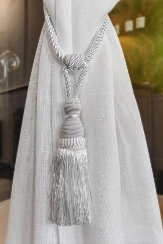 a tassel on a white dress with a necklace at ORCHID SUITES - Historic Palm Beach Hotel Condominium in Palm Beach