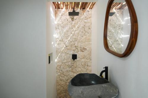 a bathroom with a sink and a mirror at Ombara Resort Mentawai in Katiet