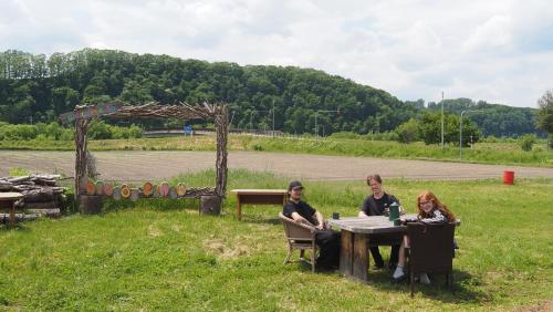three women sitting at a table in a field at TOTONOU Place in Asahikawa