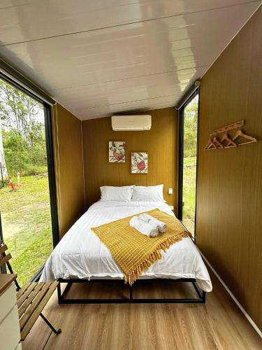 a bed in a small room with a large window at Mirror Reflections 2 by Tiny Away in Tamborine