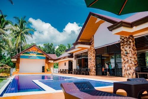 a villa with a swimming pool and a resort at H&P Beach Resort in Pandan