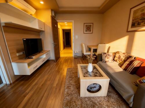 a living room with a couch and a tv at Treasure Condo Kitchenette Wifi in Chiang Mai