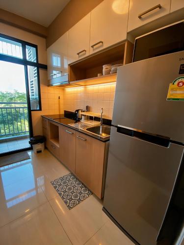 a kitchen with a stainless steel refrigerator and a sink at Treasure Condo Kitchenette Wifi in Chiang Mai