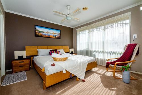a bedroom with a bed and a ceiling fan at Brightside , Great family home near Airport in Craigieburn
