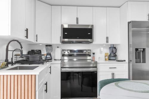 a kitchen with white cabinets and a stainless steel appliance at The Oasis Signature in Miami