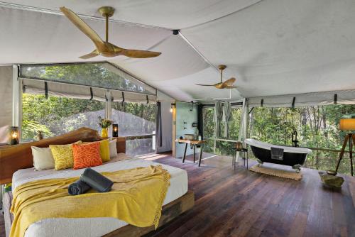 a bedroom with a bed and a tub in a room at Starry Nights Luxury Camping in Woombye