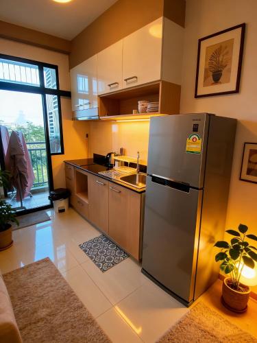 a kitchen with a stainless steel refrigerator and a sink at treasure swimming condo in Chiang Mai