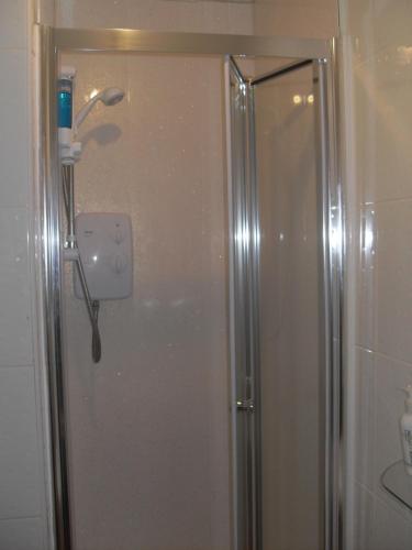 a shower with a glass door in a bathroom at Beeches Hotel in Blackpool
